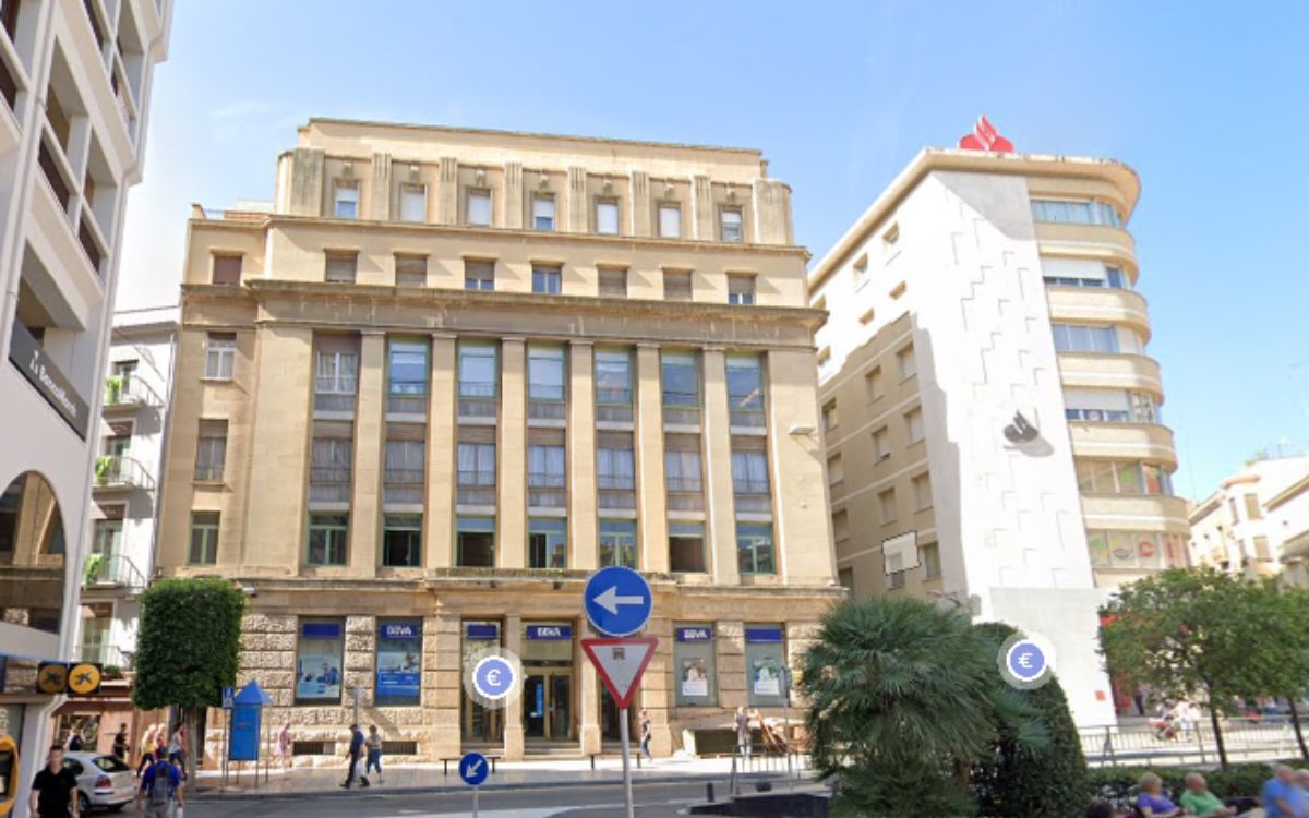 La seu bancària es troba en una de les cantonades de la plaça del Prim, a l'inici del Raval de Jesús