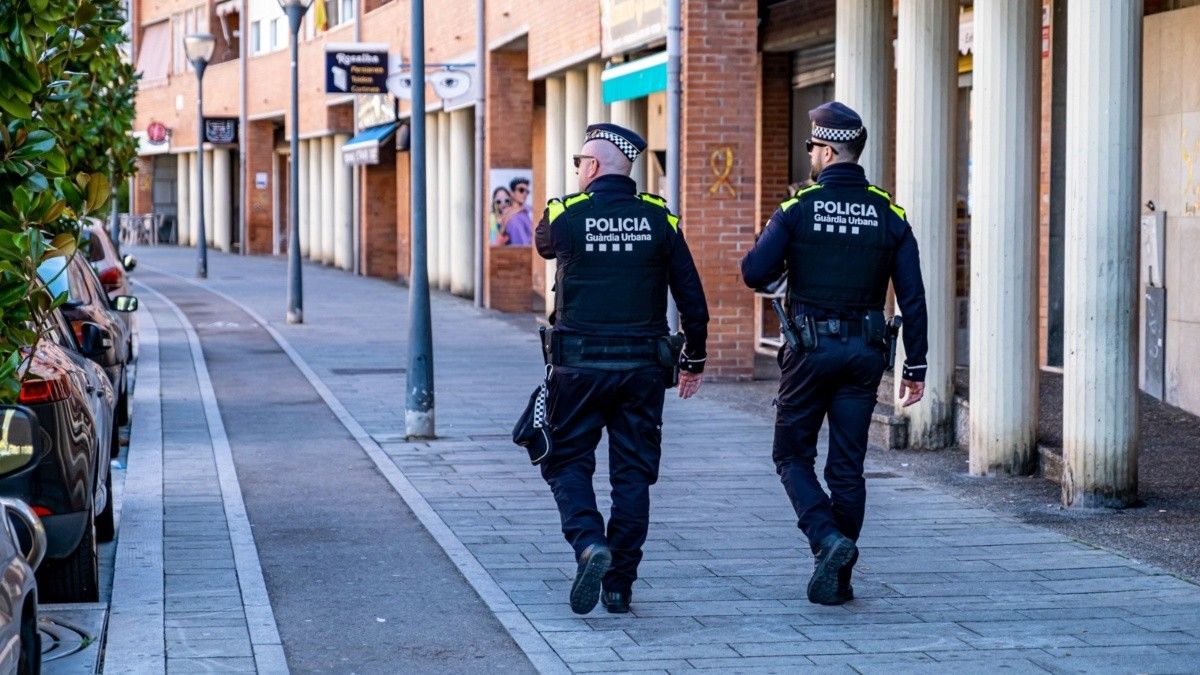 Dos agents de la Guàrdia Urbana patrullen a peu per la Rambla de Ponent de Campclar.