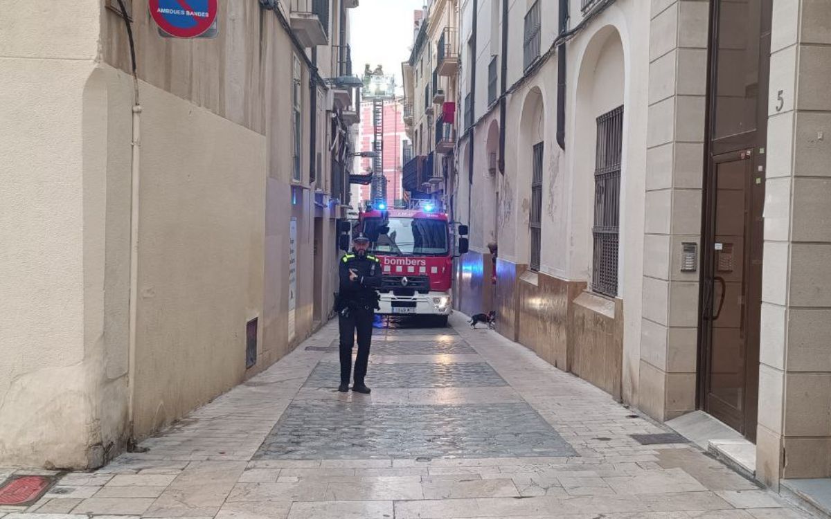 Un agent de la Guàrdia Urbana tallant el pas al carrer per seguretat