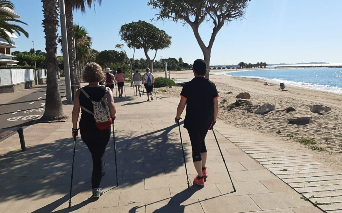 Imatge d'un grup de persones caminant pel passeig de la platja a Cambrils